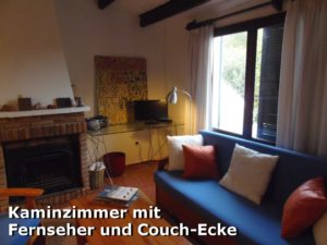 Kaminzimmer mit Couch und Fernseher in der Villa Eibisch